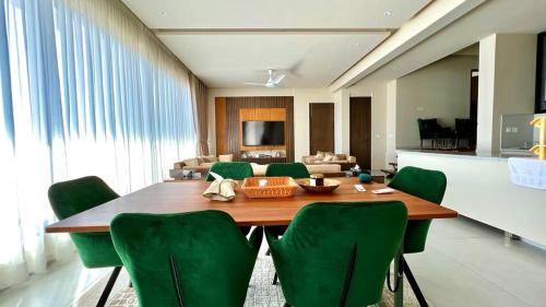 a dining room with a table and green chairs at 2 Bed Royal in Murree