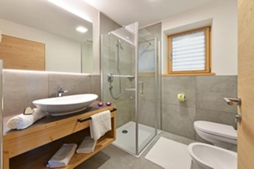 a bathroom with a sink and a shower at Forchnerhof -Appartement Dolomitenblick in Rodengo
