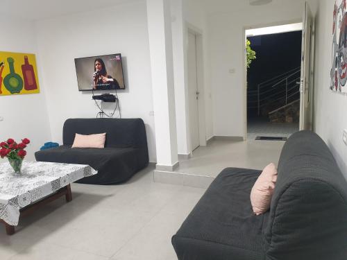 a living room with two couches and a table at חצבים על הואדי in Arad