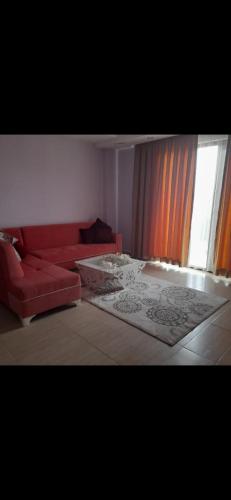 a living room with a red couch and a window at Özbudak termal tatil köyü. eski adı Sefa termal tatil köyü in Gazligol