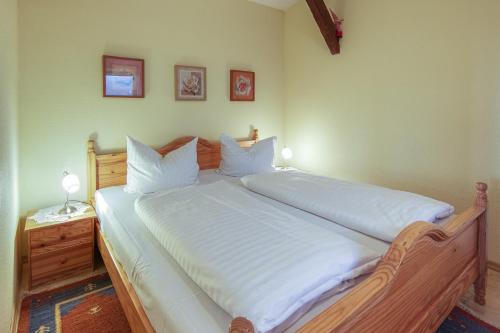 a bedroom with a large bed with white sheets at Ferienwohnung " Müritzblick " in Waren