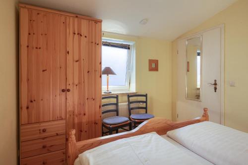 ヴァーレンにあるFerienwohnung " Müritzblick "のベッドルーム1室(ベッド1台、キャビネット、窓付)