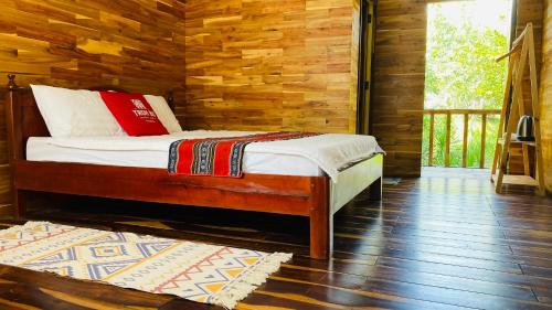 a bedroom with a bed in a log cabin at Troh Bư's Bungalows in Buôn Niêng