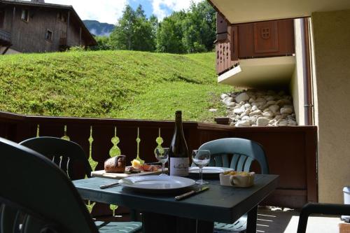 - une table avec une bouteille de vin sur le balcon dans l'établissement 2 bedroom Apartment in Les Houches Stone's throw from Prairon lift, aux Houches