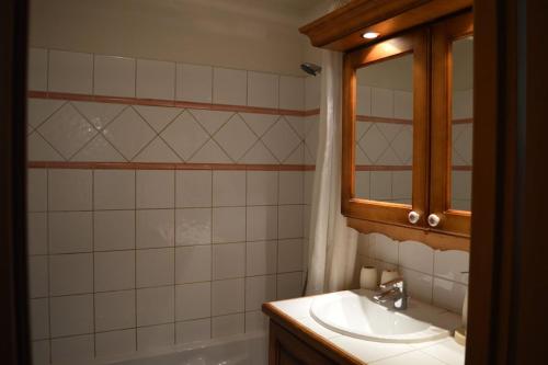 une salle de bain avec un lavabo, un miroir et une baignoire dans l'établissement 2 bedroom Apartment in Les Houches Stone's throw from Prairon lift, aux Houches
