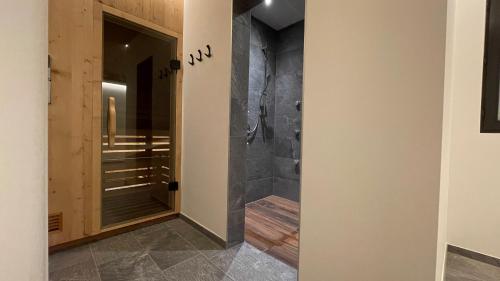 a bathroom with a walk in shower next to a glass door at Residence Tantalus in San Lorenzo di Sebato