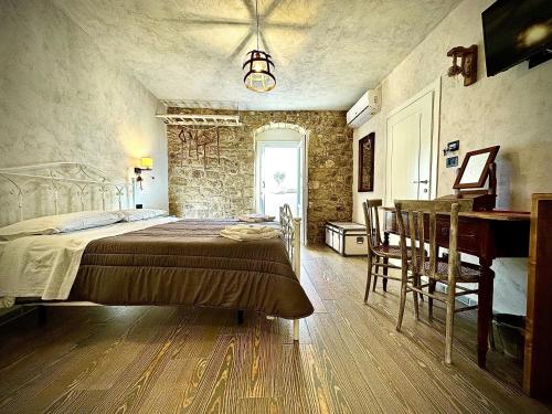 a bedroom with a bed and a desk in a room at Cuturissi Hospitality & Wellness in Ragusa