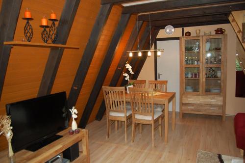 a dining room with a table and a television at Ferienhaus Bergblick am See in Waldkirchen