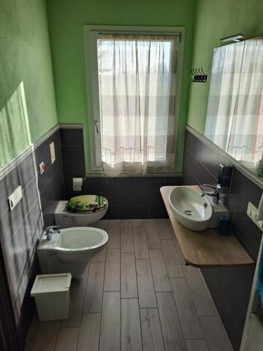 a bathroom with a toilet and a sink and a tub at B&B Ai Prati in Lesignana