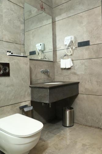 een badkamer met een toilet en een wastafel bij Rudra Royals in Shirdi