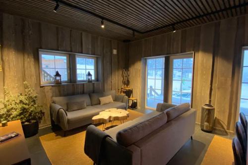 ein Wohnzimmer mit einem Sofa und einem Tisch in der Unterkunft Modern Stuga med Ski Lodge känsla in Järvsö