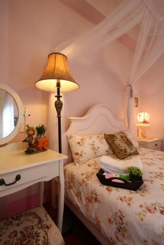 a bedroom with a bed with a lamp and a mirror at Hope & Sea Homestay in Hualien City