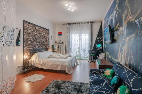 um quarto com uma cama e um sofá em Hostel Art em Trieste