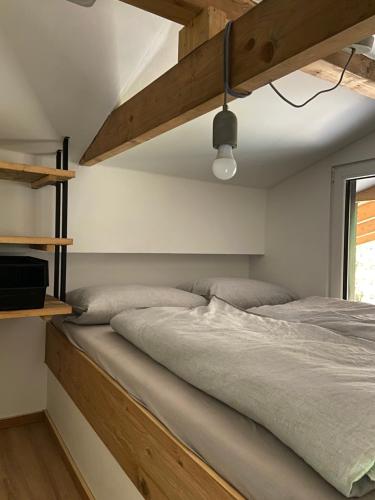 Modernes Tinyhouse Trailer Cabins am Waldrand - mit Seezugang في إجينغ: غرفة نوم بسرير كبير مع اطار خشبي