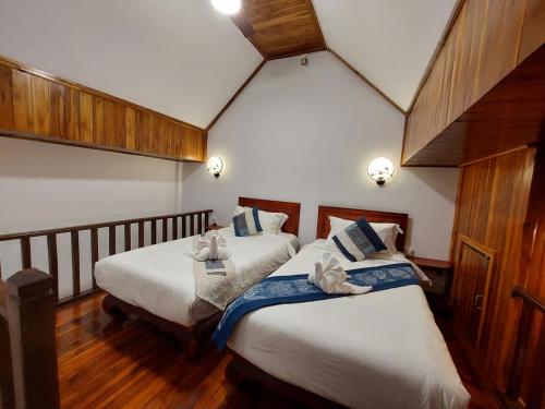 a bedroom with two beds with towels on them at wisdom mystery Hotel in Luang Prabang