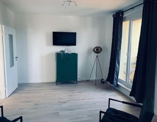sala de estar con TV y armario verde en cozy Apartment in Cottbus Work 2 en Cottbus