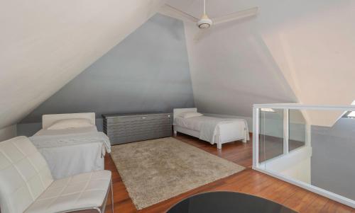 a attic room with a bed and a couch at Balinea Villas in Pereybere