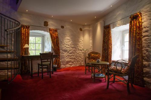 a living room with a staircase and chairs and a table at Hotel Burg Kerpen in Illingen