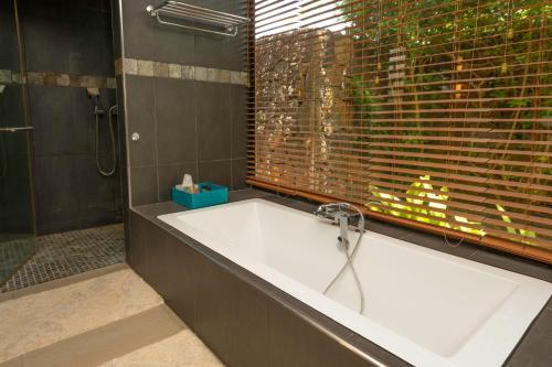 a bath tub in a bathroom with a window at Balinea Villas in Pereybere