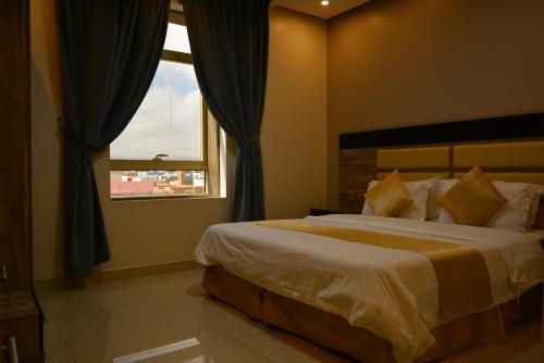 a bedroom with a large bed and a window at بيت الماس للشقق المخدومة MAAS House Apartments in Abha