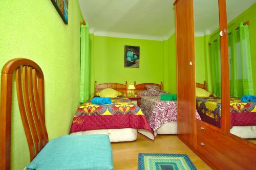Un dormitorio con dos camas y paredes verdes. en CLEOPATRA APARTMENT, en Alicante