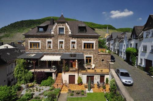 ein großes Haus mit einem davor geparkt in der Unterkunft Altes Weingut an der Vogtei in Senheim