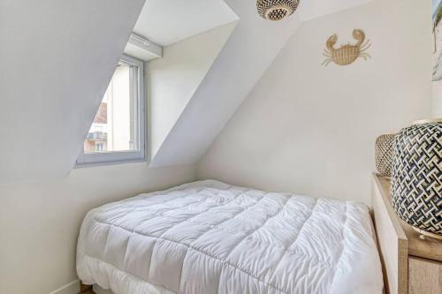 une chambre blanche avec un lit et une fenêtre dans l'établissement Cabourg Emeraude 2 étoiles plage et thalasso 100m parking gratuit, à Cabourg