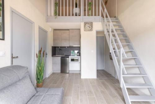 un salon avec un escalier et une cuisine dans l'établissement Cabourg Emeraude 2 étoiles plage et thalasso 100m parking gratuit, à Cabourg