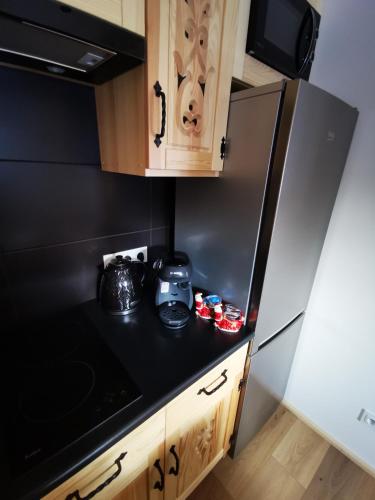 a kitchen with a black counter top and a refrigerator at Heidi in Zakopane