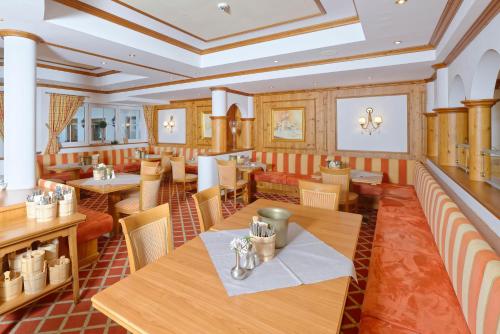 a restaurant with wooden tables and chairs at Ortnerhof - Ihr Zuhause am Fuße der Alpen in Ruhpolding