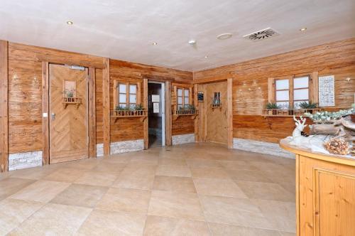 Großes Zimmer mit Holzwänden und Fliesenboden. in der Unterkunft Ortnerhof -Das Wohlfühlhotel in Ruhpolding