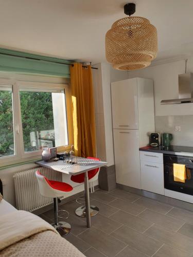a kitchen with a table and a sink in a room at CocooningSpace tout équipé + parking privé in Mulhouse