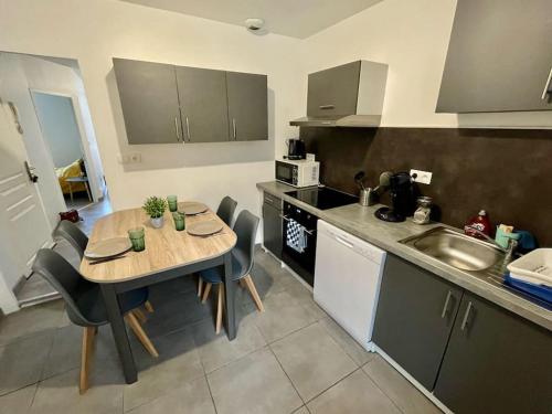 a kitchen with a table and chairs and a sink at Appartement le Rhôn'ain - Vue Rhône - Lit Queen size in Bellegarde-sur-Valserine