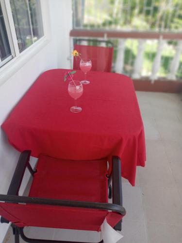 una mesa roja con dos vasos y una silla roja en Royal Villa 360 en Port Antonio