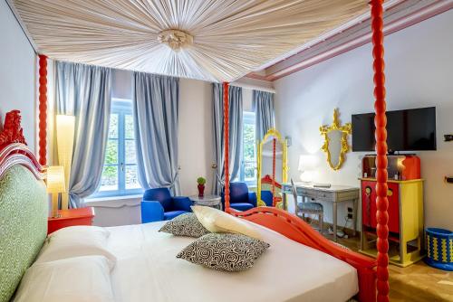 um quarto com uma cama de dossel vermelho em Byblos Art Hotel Villa Amistà em San Pietro in Cariano