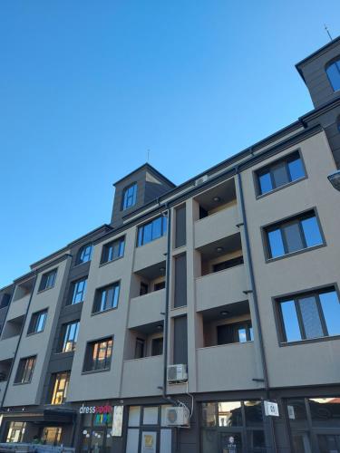 un edificio de apartamentos con un cielo azul en el fondo en Vazov Apartment, en Kazanlak