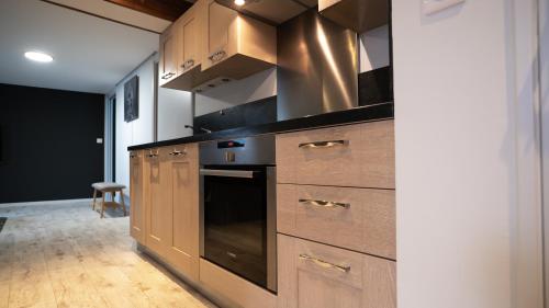 a kitchen with wooden cabinets and a stove at Maison Souply in Châlons-en-Champagne