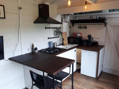 a kitchen with a wooden table and a stove at Tiny house, sauna hot tub Gesves Namur Ardennes in Gesves