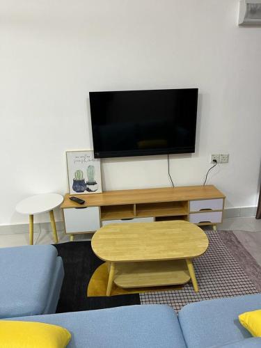 a living room with a couch and a table and a tv at Sure Stay Homestay in Simpang Ampat