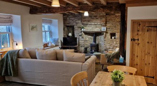 a living room with a couch and a fireplace at Cringley Cottage in Askrigg