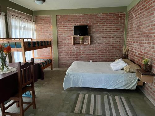 a bedroom with a bed and a brick wall at Maryfer in Las Grutas