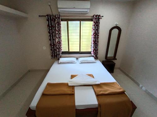 a bedroom with a large bed with a window at Konkan Villa Dream in Malvan