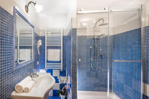 ローマにあるAffittacamere Guest House Glatimiaの青いタイル張りのバスルーム(シンク、シャワー付)