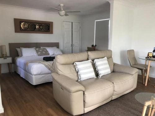 a living room with a couch and a bed at Lakeside Bungalow in Marks Point