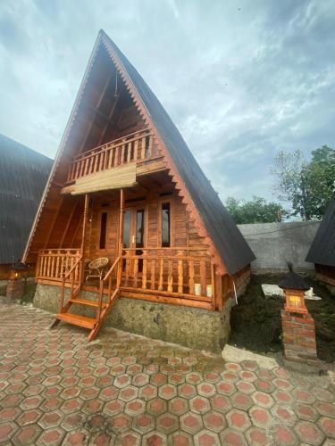 Resort & Resto Talaga Sundayana في سوبانج: منزل خشبي كبير مع سقف مقامر