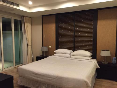 una camera da letto con un grande letto con lenzuola e cuscini bianchi di AMAZING BIG APARTMENT IN SOUTH PHUKET a Phuket