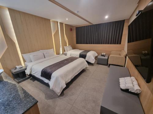 um quarto de hotel com duas camas e uma casa de banho em Yeoubi Hotel em Jinju