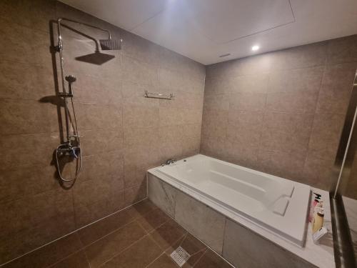 a bathroom with a bath tub and a shower at Yeoubi Hotel in Jinju
