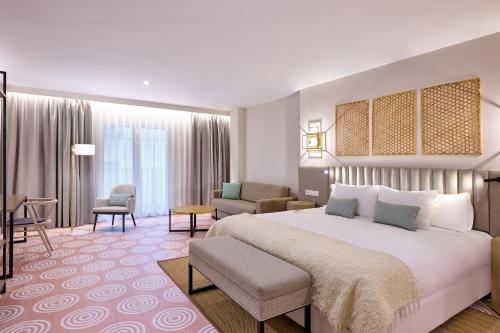 um quarto de hotel com uma cama grande e uma sala de estar em Boutique Hotel Luna Granada Centro em Granada