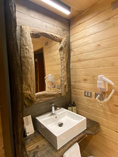 bagno con lavandino bianco e specchio di NI-NEWEN Hotel & Lodge a Pucón